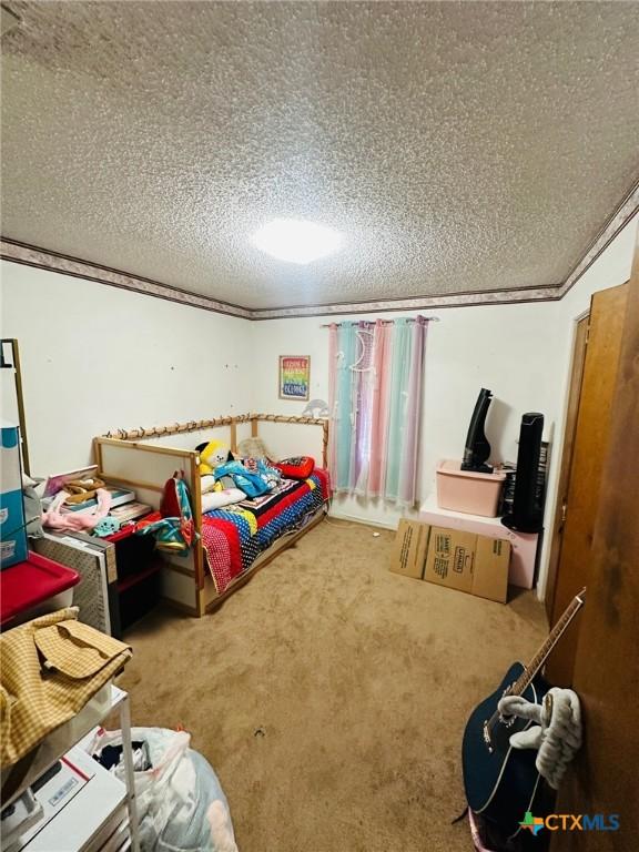 218 Monterrey Dr, Victoria, TX 77904 - bedroom featuring a textured ceiling, carpet floors, and ornamental molding