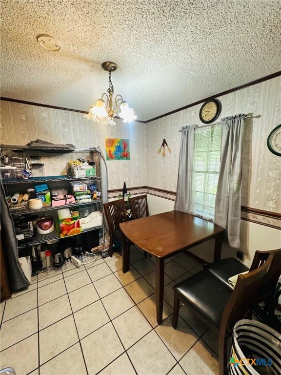 218 Monterrey Dr, Victoria, TX 77904 - dining space featuring a chandelier, light tile patterned floors, a textured ceiling, and wallpapered walls