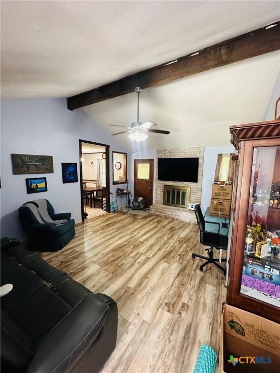 218 Monterrey Dr, Victoria, TX 77904 - living area featuring wood finished floors, a ceiling fan, and a fireplace