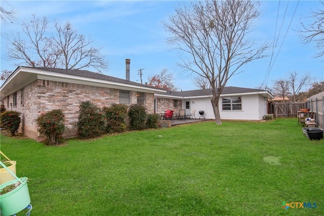 rear view of property with central AC unit and a lawn