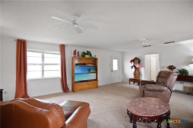 carpeted living room featuring ceiling fan and a textured ceiling