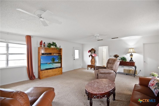 living room featuring light carpet, plenty of natural light, and ceiling fan