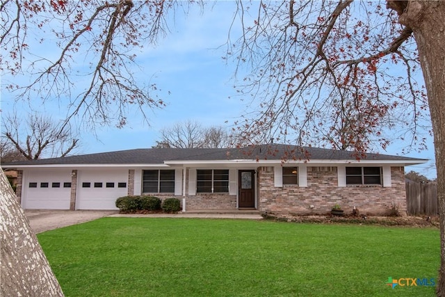 ranch-style house featuring a garage and a front lawn