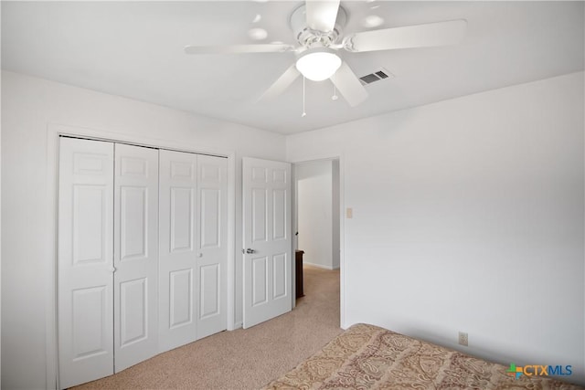 unfurnished bedroom with a closet, ceiling fan, and light carpet