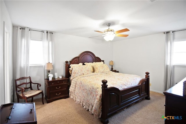 bedroom with multiple windows, light colored carpet, and ceiling fan