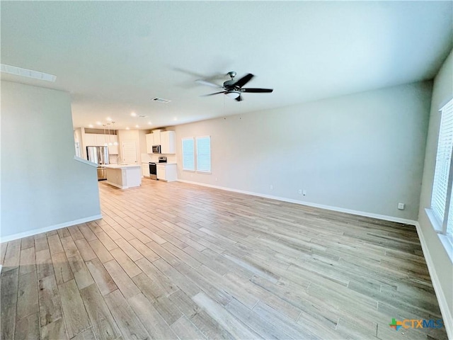 unfurnished living room featuring ceiling fan and light hardwood / wood-style flooring