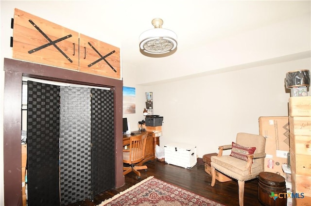 bedroom with wood finished floors and an office area