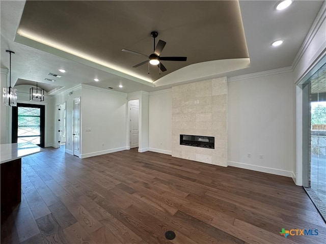 425 Dos Rios Dr, Belton, TX 76513 - unfurnished living room featuring ceiling fan, a tray ceiling, baseboards, a chandelier, and dark wood-style floors