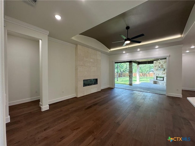 425 Dos Rios Dr, Belton, TX 76513 - unfurnished living room featuring a tiled fireplace, a tray ceiling, a ceiling fan, ornamental molding, and dark wood finished floors