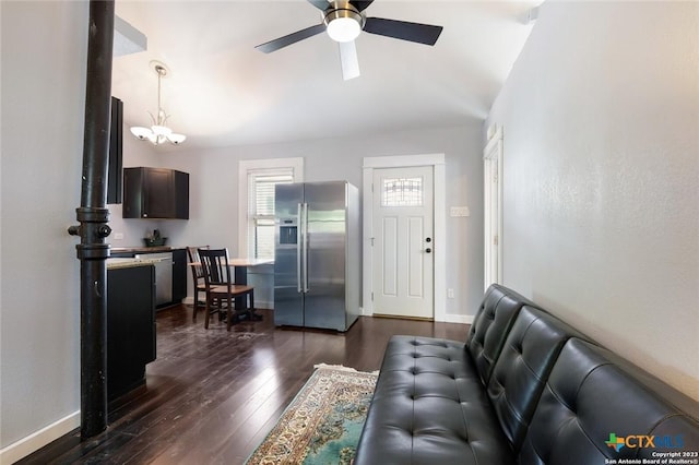 living room with ceiling fan with notable chandelier and dark hardwood / wood-style floors