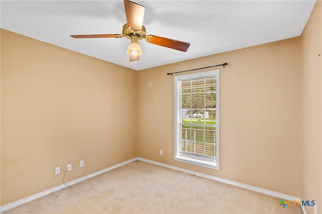 spare room featuring a textured ceiling, light colored carpet, and ceiling fan