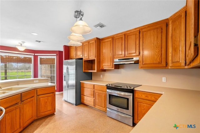 kitchen with appliances with stainless steel finishes, sink, and decorative light fixtures