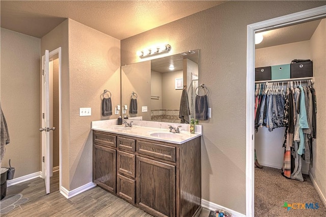 bathroom featuring vanity, wood-type flooring, and a textured ceiling