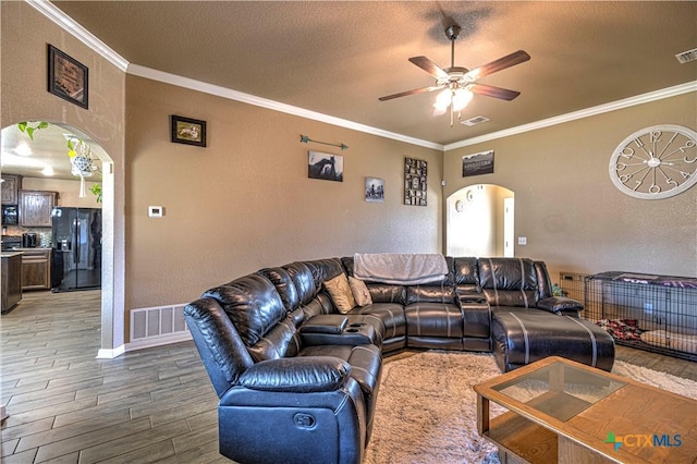 living room featuring hardwood / wood-style floors, a textured ceiling, ceiling fan, and crown molding