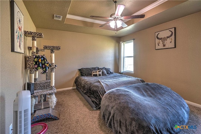 bedroom featuring ceiling fan, a raised ceiling, carpet floors, and ornamental molding