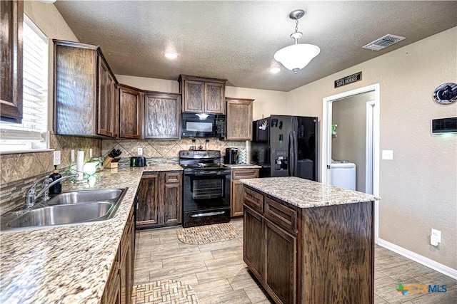 kitchen featuring sink, backsplash, a kitchen island, and black appliances