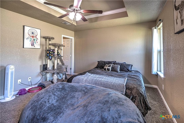 carpeted bedroom featuring a tray ceiling and ceiling fan