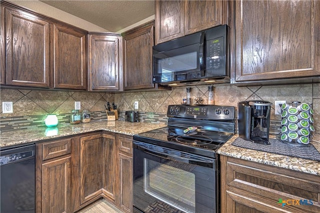 kitchen featuring backsplash, black appliances, a textured ceiling, dark brown cabinets, and light stone counters