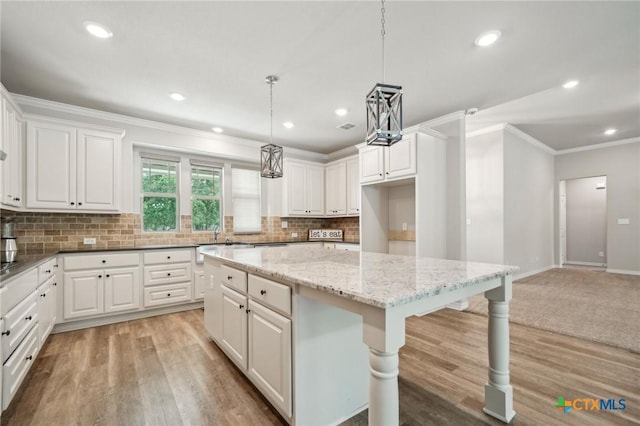 4049 Hickory Forrest Dr, Seguin, TX 78155 - kitchen featuring ornamental molding, backsplash, white cabinets, light stone counters, and a kitchen island