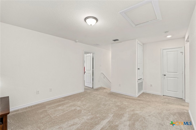 unfurnished room featuring light colored carpet and a textured ceiling