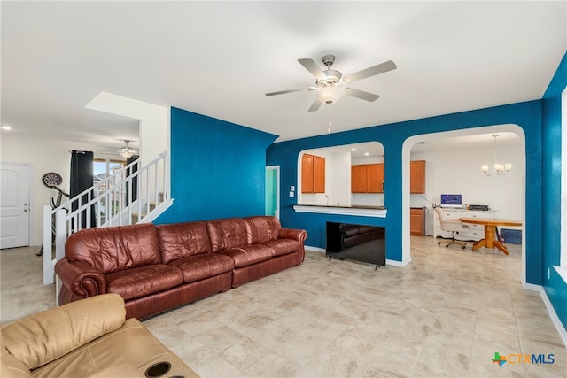 living room with ceiling fan with notable chandelier