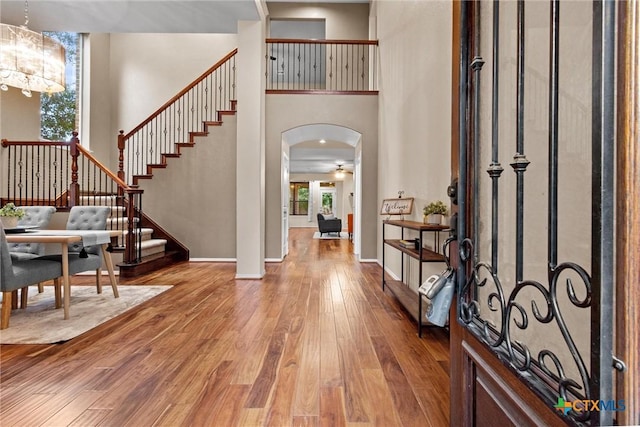 foyer entrance featuring hardwood / wood-style flooring, a chandelier, and a high ceiling