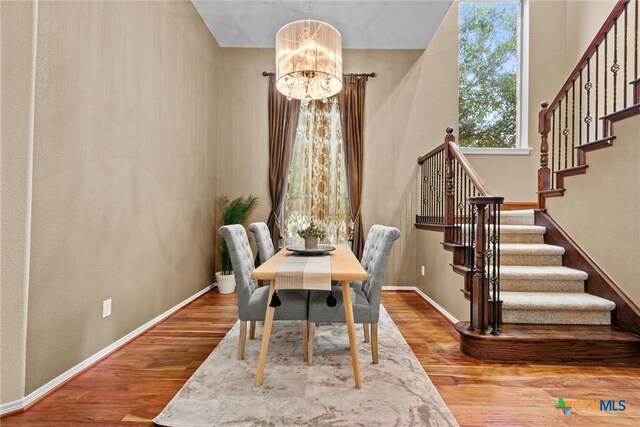 dining room with hardwood / wood-style flooring and a chandelier