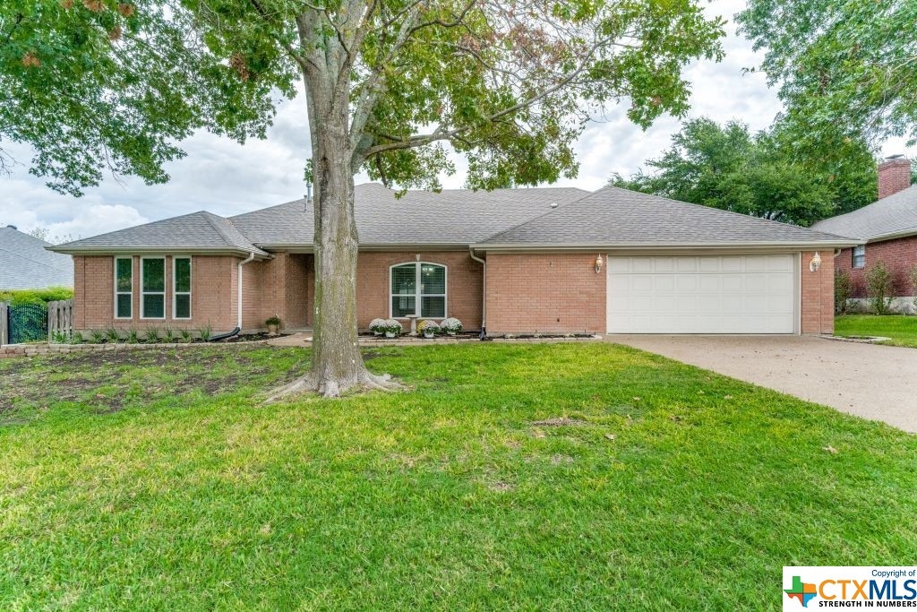 ranch-style home featuring a garage and a front yard