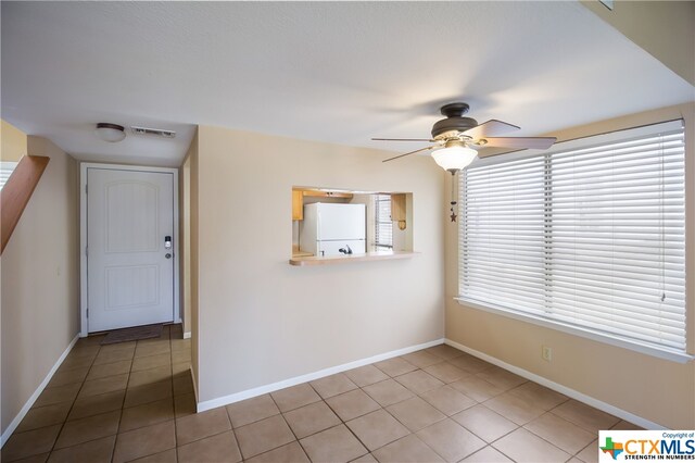 tiled empty room with ceiling fan