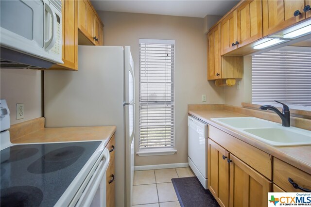 kitchen featuring white appliances, light tile patterned flooring, and sink