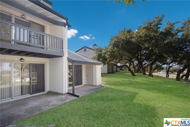 view of yard with a balcony and a patio area