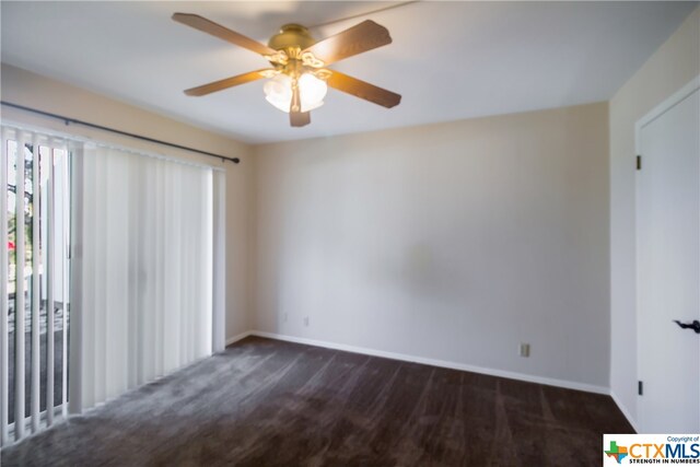 empty room with dark colored carpet and ceiling fan