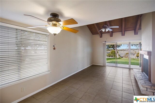 spare room featuring tile patterned flooring, ceiling fan, and vaulted ceiling with beams