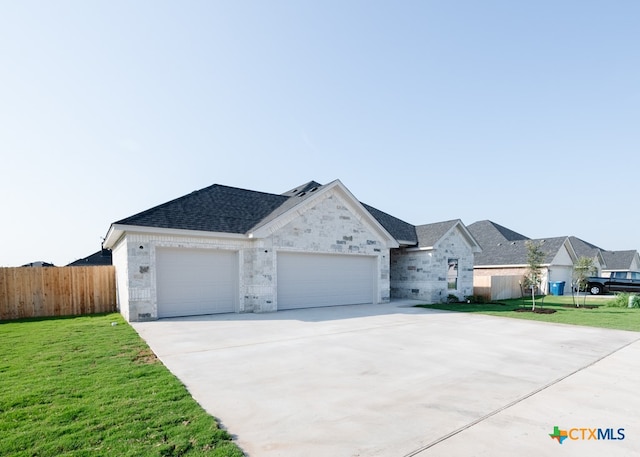 single story home featuring a garage and a front yard