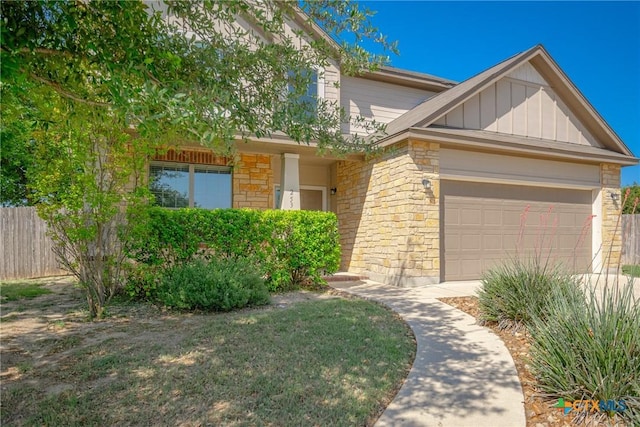 253 Flushing, New Braunfels, TX 78130 - view of front facade with board and batten siding, fence, stone siding, and a garage
