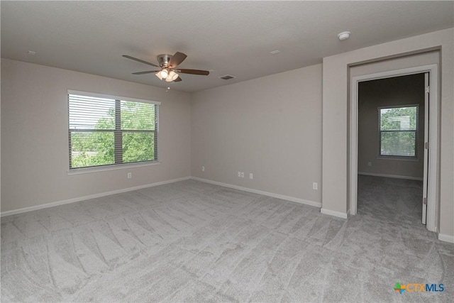 253 Flushing, New Braunfels, TX 78130 - empty room featuring light carpet, a wealth of natural light, baseboards, and ceiling fan