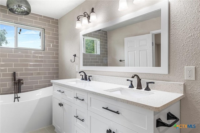 111 Warwick Glen St, Victoria, TX 77904 - full bath featuring a textured wall, double vanity, and a freestanding tub