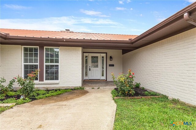 111 Warwick Glen St, Victoria, TX 77904 - entrance to property featuring a metal roof and brick siding