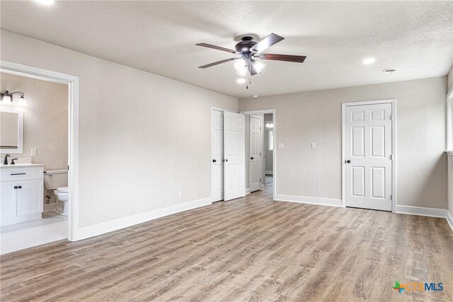 111 Warwick Glen St, Victoria, TX 77904 - unfurnished bedroom with light wood-type flooring, ensuite bath, a textured ceiling, and ceiling fan