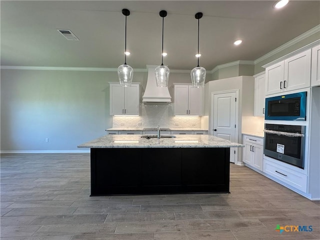 2032 Yarrow Rd, Temple, TX 76502 - kitchen featuring stainless steel oven, custom range hood, black microwave, crown molding, and white cabinetry