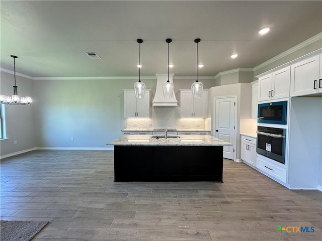 2032 Yarrow Rd, Temple, TX 76502 - kitchen featuring oven, custom range hood, black microwave, light wood finished floors, and white cabinetry