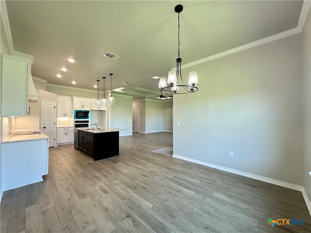 2032 Yarrow Rd, Temple, TX 76502 - kitchen with crown molding, open floor plan, a chandelier, light wood-style flooring, and black appliances