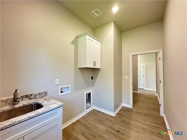 2032 Yarrow Rd, Temple, TX 76502 - washroom with cabinet space, light wood-style flooring, washer hookup, and hookup for an electric dryer