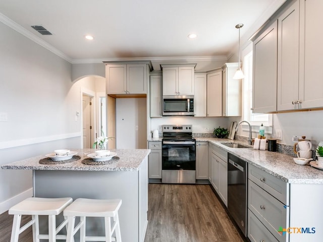 175 Lost Maples Way, Marion, TX 78124 - kitchen with stainless steel appliances, gray cabinetry, crown molding, light stone counters, and arched walkways