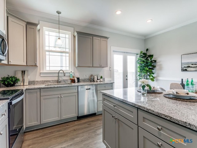 kitchen with sink, stainless steel appliances, hardwood / wood-style floors, gray cabinets, and ornamental molding