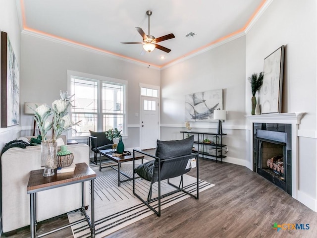 living room featuring hardwood / wood-style flooring, ceiling fan, and ornamental molding