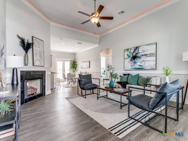 175 Lost Maples Way, Marion, TX 78124 - living area featuring arched walkways, ornamental molding, ceiling fan, wood finished floors, and a tile fireplace