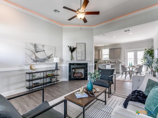 175 Lost Maples Way, Marion, TX 78124 - living room featuring light wood-type flooring, ornamental molding, ceiling fan, a tiled fireplace, and recessed lighting