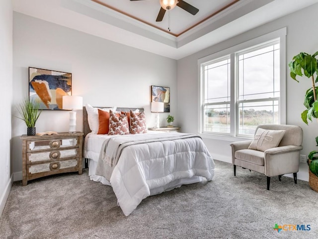 carpeted bedroom featuring ceiling fan, a raised ceiling, and crown molding