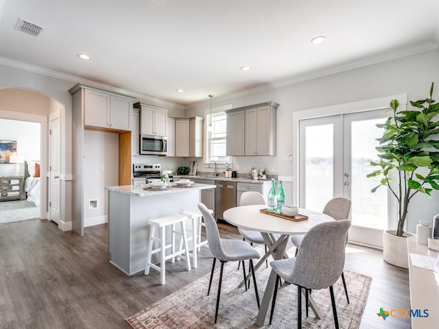 175 Lost Maples Way, Marion, TX 78124 - kitchen featuring stainless steel appliances, gray cabinetry, arched walkways, a center island, and crown molding